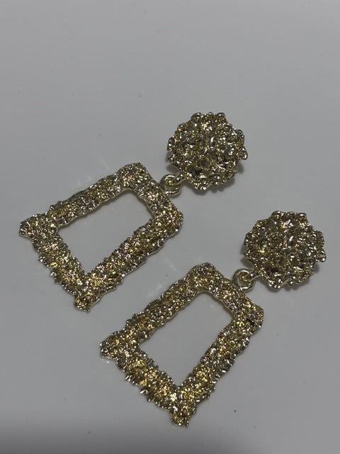 Pair of gold earrings on a gray background