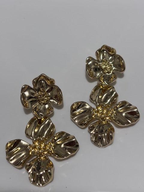 Gold floral drop earrings on a white background