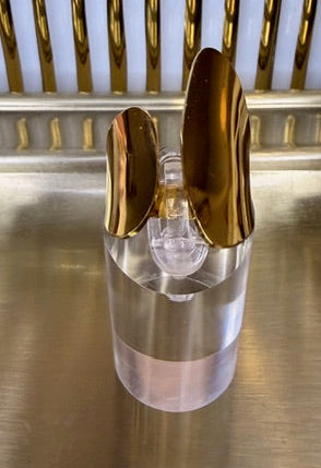 Gold ring on a clear base and on a metallic surface