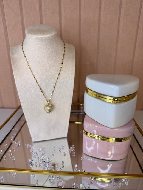 Necklace on a mannequin bust with jewelry boxes in the background