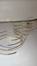 Gold arm bracelets on a white surface