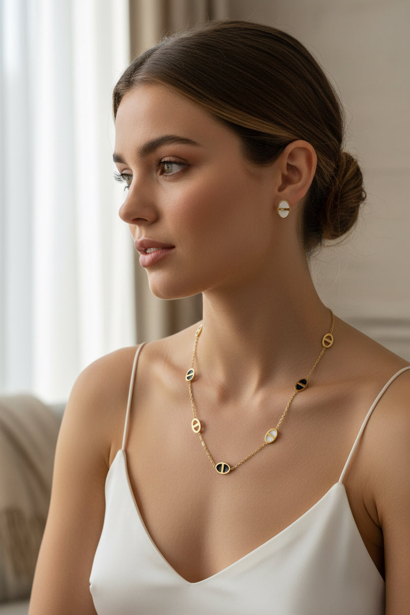 Gold Necklace with circular pendants and matching earrings on a mannequin bust against a neutral background