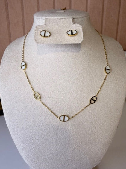 Gold Necklace with circular pendants and matching earrings on a mannequin bust against a neutral background