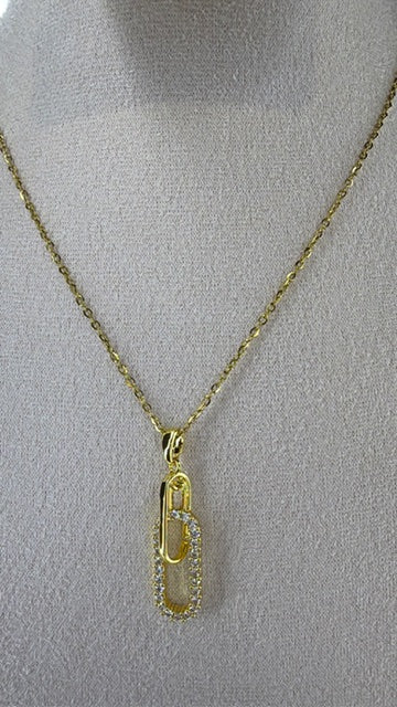 Gold necklace with a paperclip Style pendant on a gray mannequin