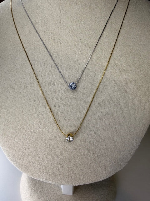 Necklace with a pendant on a beige display stand