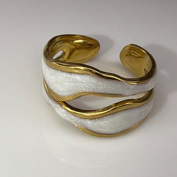 Gold and white open ring on a light gray background