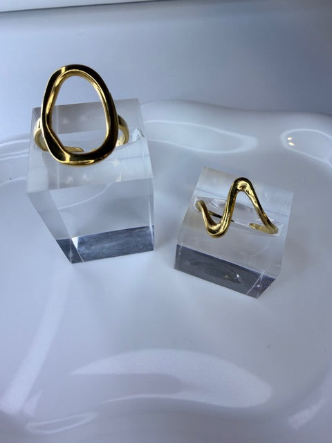 Gold rings on a clear crystal block with a white background