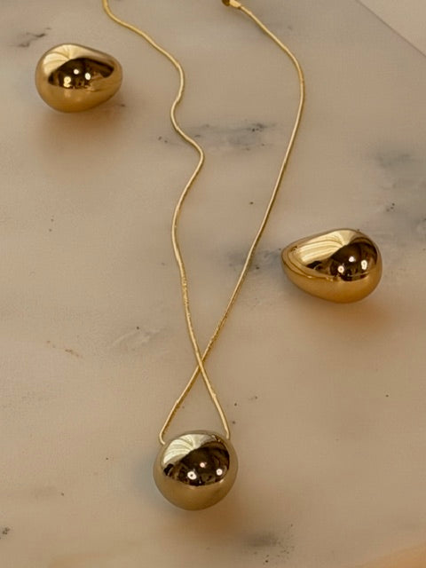 Gold pendant necklace on a marble surface