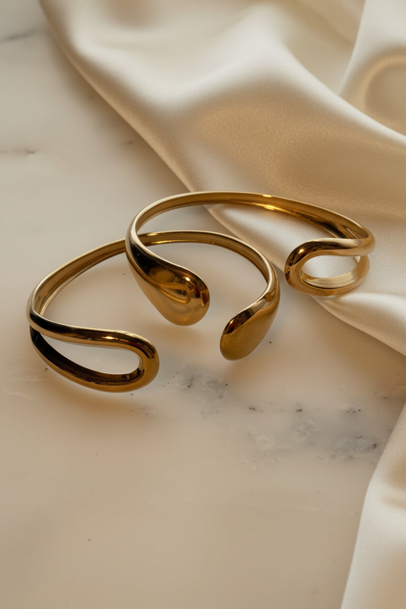 Open Gold bracelet on a marble surface