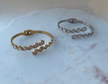 Gold and silver spring open bracelets on a marble surface