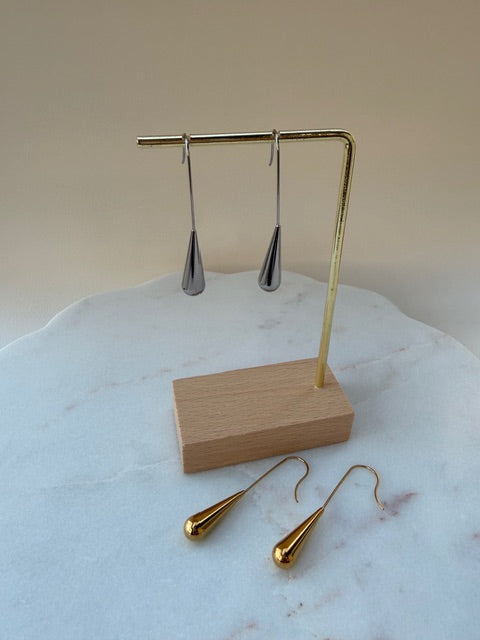 Silver earrings on a stand with a marble surface