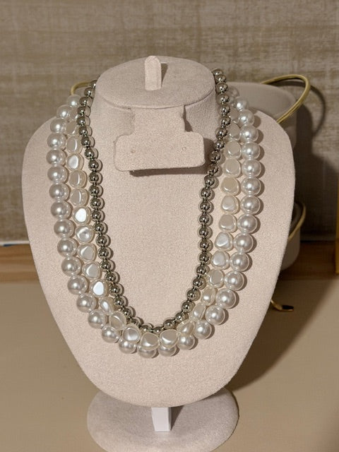 Pearl necklace on a display stand with a neutral background