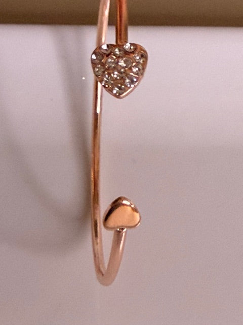 Rose gold bracelet with heart-shaped ends on a white background