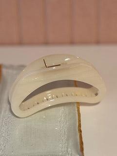 White hair clip on a white surface with a blurred background