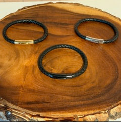 Three leather bracelets on a wooden surface