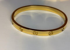 Gold bracelets with cross designs on a white background