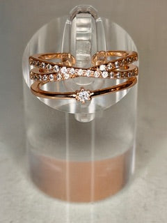 Rose gold layered ring on a clear stand with a neutral background