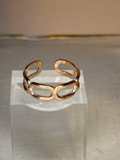 Single cable style open ring on a clear acrylic block against a neutral background