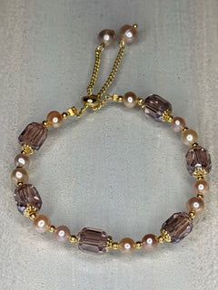 Bracelet with purple and rose pearls on a light gray background
