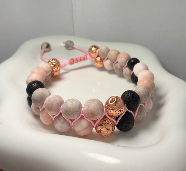 Adjustable bracelet with pink and black beads on a white surface
