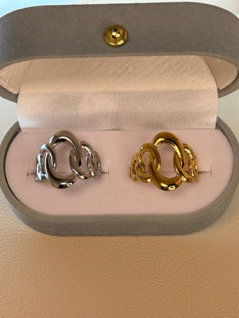 Pair of gold and silver rings in a jewelry box on a beige background