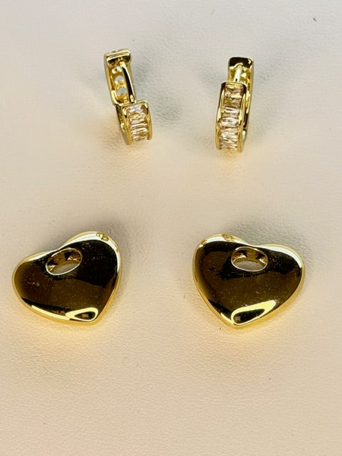 Gold earring components on a beige background