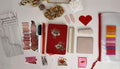 Collection of stationery items including a red pouch, scissors, and decorative elements on a white surface.