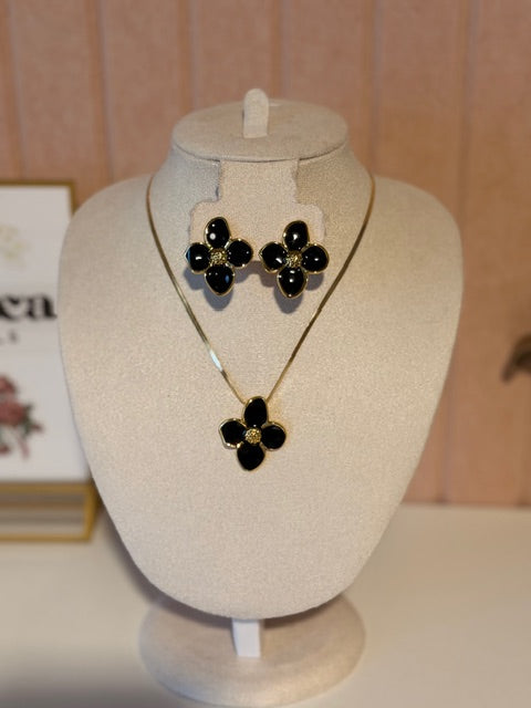 Black flower jewelry set on a mannequin bust with a neutral background