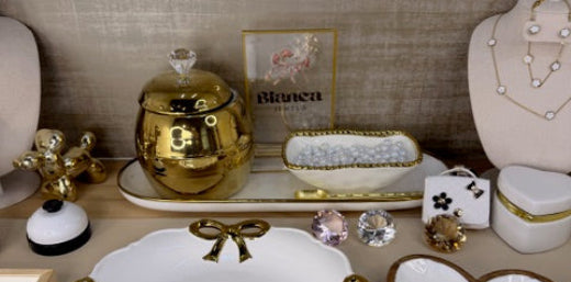 Decorative items including a heart-shaped mirror, decorative boxes, and a gold ornament on a textured surface.